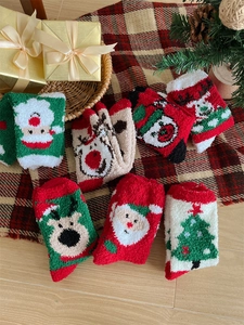 Macro view of fluffy Christmas coral fleece socks with festive reindeer and tree patterns