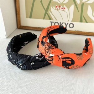 Détail de serre-têtes d'Halloween noués avec motifs de toile d'araignée, crâne et citrouille