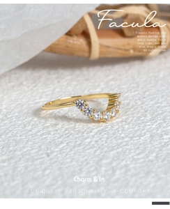 Macro detail of V-shaped gold ring with seven sparkling white zircons in a prong setting