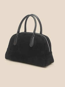 Minimalist black suede bowling bag with smooth leather handles in a retro half-round style