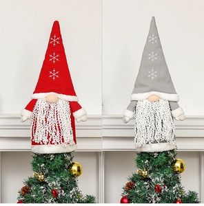 Close-up of red and grey Christmas gnome tree toppers with snowflake embroidery details