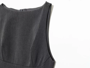 Detail of dark charcoal sleeveless dress featuring fine twill texture and precision stitching