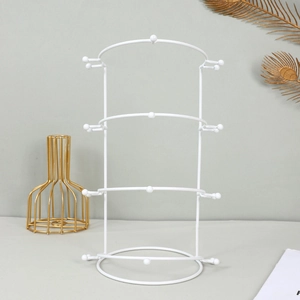 Close-up of a white 4-tier metal display stand for bridal tiaras and headbands