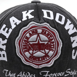 Close-up of vintage embroidery and star patch on a dark gray distressed baseball cap