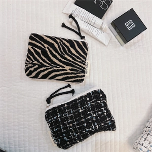 Close-up of zebra pattern and tweed zipper pouches for cosmetics and coins