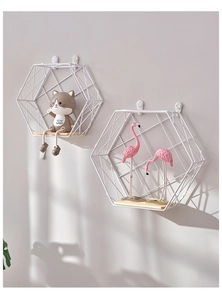 Detail of white hexagonal metal wall shelves with light wood bases in Nordic style