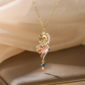 Macro detail of golden seahorse necklace with colorful gemstones and pearls