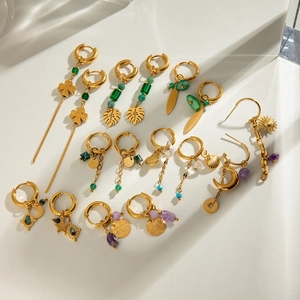Detailed flat lay of gold-plated stainless steel earrings with natural stones and charms