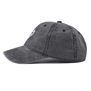 Close-up of white heart embroidery and stitch detail on washed grey baseball cap