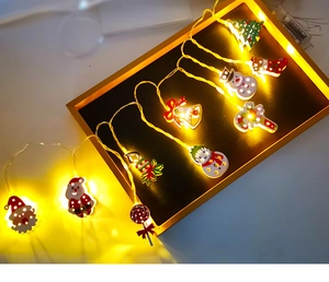 Close-up of warm yellow LED Christmas lights with iron Santa and snowman shapes