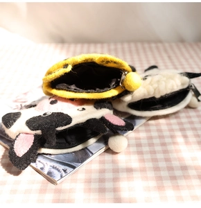 Close-up of cute felt animal coin purses with cow pattern and zip closure detail