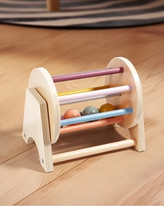 Detail of Montessori wooden scrolling drum with colorful bars for infant sensory development