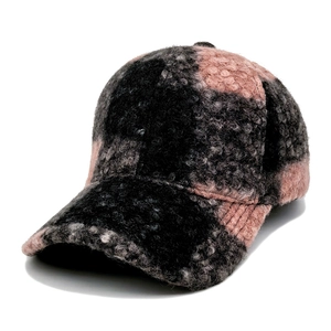 Detail of pink and black checkered teddy fleece texture on a warm winter baseball cap