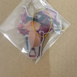 Detail of western cowboy saddle pendant keychain with gold cord in plastic packaging