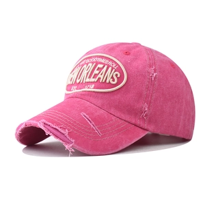 Close-up of distressed rose pink cotton baseball cap with New Orleans embroidery detail