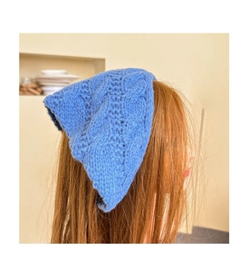 Detail of blue knit headband showing intricate cable knit texture and hollow crochet work