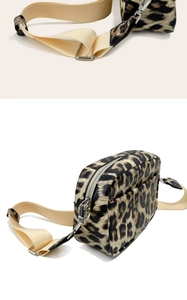 Detail of leopard print crossbody bag with beige wide strap and silver metal hooks