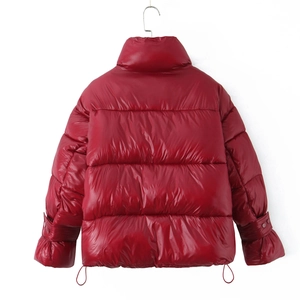 Close-up of red glossy puffer jacket featuring a stand collar and elastic cuffs