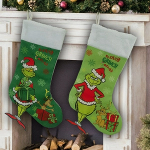 Detailed close-up of Grinch themed Christmas stockings hanging by a decorated fireplace