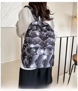 Detalle de la vista trasera de la mochila negra y gris con patrón en V y estrellas corazón