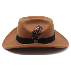 Détail du chapeau en feutre de laine camel avec ruban noir, plume et badge métallique rétro