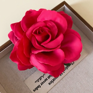Detail of a handmade red fabric rose hair clip and brooch with layered silk petals