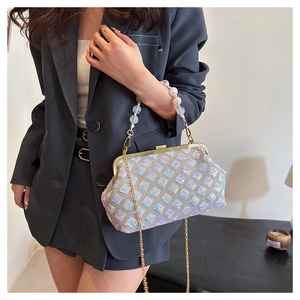 Detail of silver sequin evening shell bag with pearl handle and golden chain strap