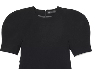 Detailed view of the structured puff sleeves and round neckline on a black mini dress