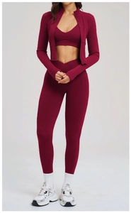 Detail of burgundy three-piece yoga set with zip jacket, sports bra and v-waist leggings