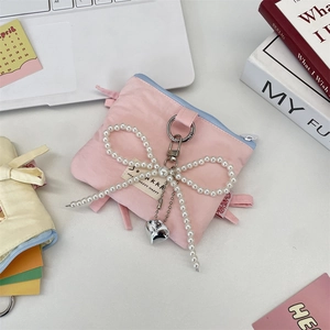 Close-up of pink fabric card holder with pearl bow charm and blue zipper detail