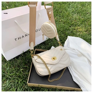 Detail of off-white quilted crossbody bag with gold chain strap and mini round pouch