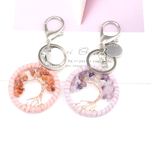 Detail shot of handmade Tree of Life dreamcatcher keychains in pink and purple quartz