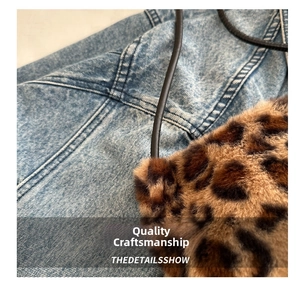 Detail of leopard print faux fur tote bag with black slim straps against denim