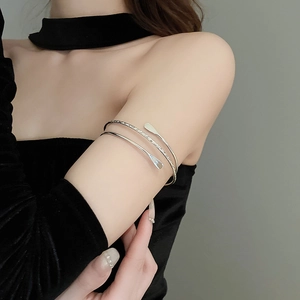 Detail of silver multi-layer spiral upper arm bracelet with twisted rope texture finish