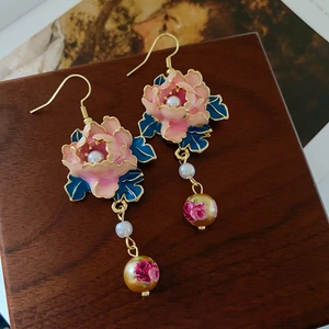 Nahaufnahme von Vintage-Blumenohrringen mit rosa Öl, Perlen und goldenen Haken-Details