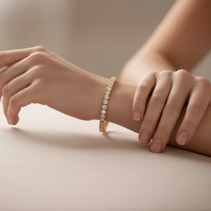 Dettaglio di un bracciale tennis dorato con zirconi tondi indossato sul polso dell'utente