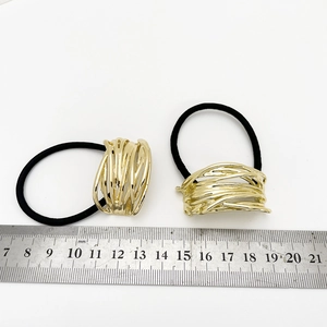 Macro shot of U-shaped gold alloy hair ties with bird nest texture on a white background