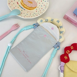 Détail du sac de téléphone bleu clair avec broderie rose et poignée jaune ondulée