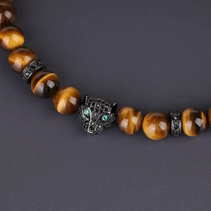 Macro shot of 8mm tiger eye stone beads and leopard head charm with green zircon eyes