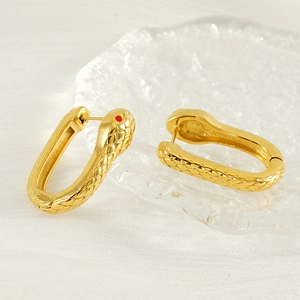 Snake hoop earrings in gold plated steel with textured scales and red gemstone eyes