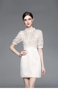 Close-up of beaded ivory lace bodice and satin skirt on elegant short sleeve dress