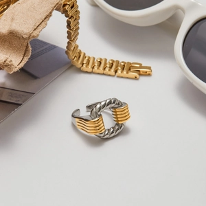 Détail de la bague ouverte torsadée bicolore avec des accessoires de mode élégants