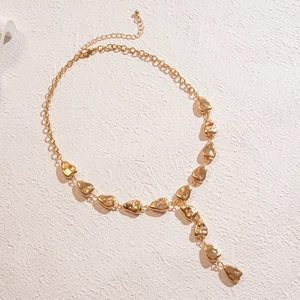 Elegant gold Y-shaped necklace featuring polished irregular heart charms on a white surface
