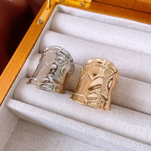 Detailed close-up of textured gold and silver irregular hammered open rings in a gift box
