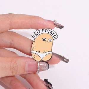 Gros plan du pin's émaillé Hot Potato avec design cartoon humoristique et métal