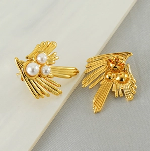 Detail view showing front and back of 18K gold swallow pearl earrings on stone texture