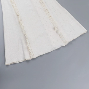 Detail der weißen Lochstickerei und des Rüschensaums an einem Sommerkleid im französischen Stil