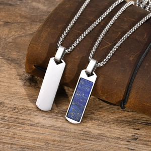 Close-up of rectangular lapis lazuli and polished silver stainless steel pendants on leather