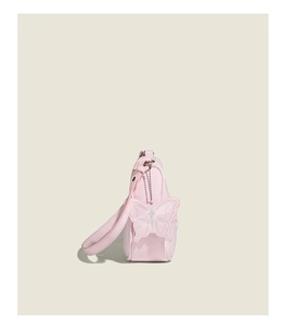 Close-up of pink PU leather crossbody bag featuring a delicate butterfly charm accessory