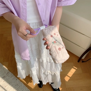 Detailed view of pink quilted pencil case with white dog embroidery and purple braided handle